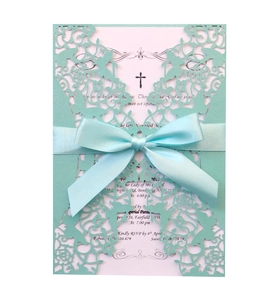 Detailed laser-cut mint green invitation card with satin ribbon and floral hollow pattern