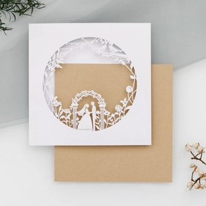 Detailed laser-cut wedding invitation featuring a romantic couple silhouette and floral lace