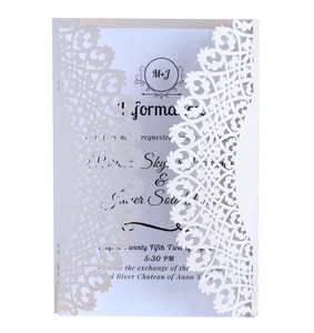 Détail d'invitation de mariage blanche découpée au laser avec motifs dentelle floraux
