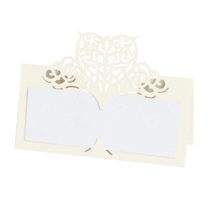 Detail of laser-cut heart pattern on cream wedding place cards for table seating