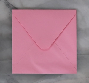 Square pink paper envelope with V-flap design on grey marble background detail