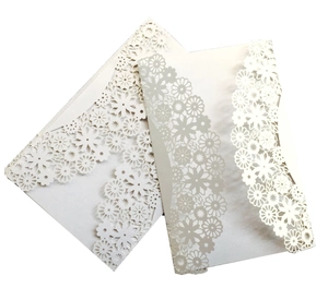 Detail of laser-cut floral wedding invitation in ivory white specialty paper