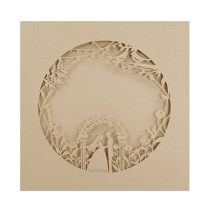 Detail of laser-cut wedding invitation featuring bride and groom silhouette in pearl gold