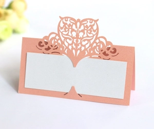 Detailed laser-cut heart pattern on pink pearlescent cardstock for wedding seat cards