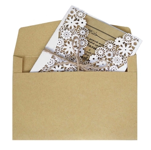 Detailed laser-cut floral wedding invitation with brown kraft envelope and jute twine