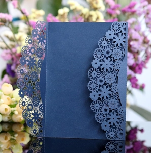 Détail des motifs floraux découpés au laser sur une invitation de mariage bleu marine