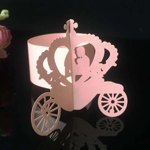 Detail of pink laser-cut carriage and crown paper napkin rings for wedding decor