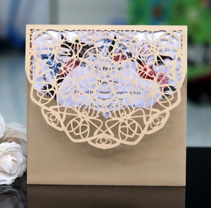 Close-up of laser-cut wedding invitation with intricate mandala patterns and floral insert