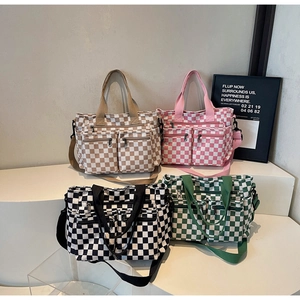 Detail of four colorful checkered canvas bags with double front pockets and adjustable straps
