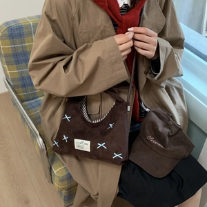 Detail of dark brown corduroy bag and cap set featuring a blue 3D bow and embroidery