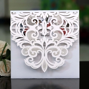 Gros plan d'une invitation de mariage découpée au laser blanc avec motif baroque