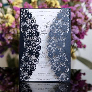 Vue macro d'invitation de mariage bleue découpée au laser avec motifs floraux précis