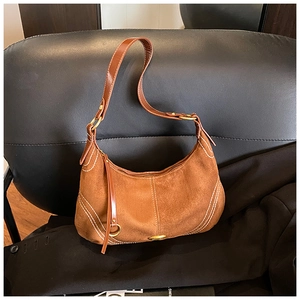 Detail of brown suede hobo bag with white contrast stitching and vintage gold buckle