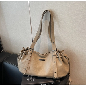 Détail d'un grand sac cabas en cuir grainé kaki avec cordons de serrage sur les côtés