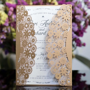 Detail of laser-cut floral wedding invitation with kraft paper cover and white printed insert
