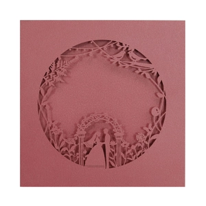 Macro detail of laser-cut wedding invitation showing romantic couple silhouette and floral lace