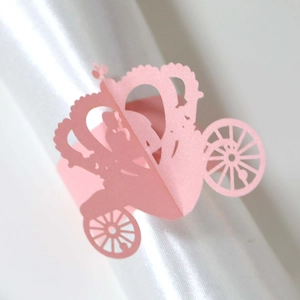 Macro shot of pink laser-cut pumpkin carriage paper napkin ring for wedding decor