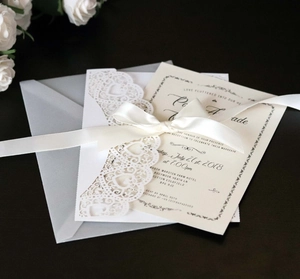 Elegant laser-cut heart wedding invitation set with satin ribbon and vellum envelope