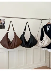 Detail of hobo tote bags in brown, black and beige with metallic silver ring hardware