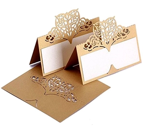 Macro detail of laser-cut champagne gold place card with intricate heart and floral patterns