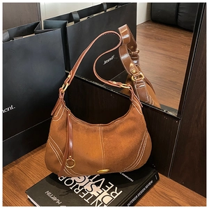 Detail of dark brown suede Hobo bag with white contrast stitching and gold metal hardware
