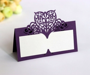 Detail of purple laser-cut wedding place card with hollow heart crown and name slot