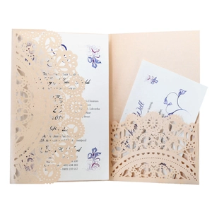 Detail of champagne laser-cut lace wedding invitation with pearl paper texture and card set