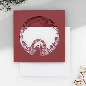 Detailed laser-cut hollow wedding invitation card with floral arch design and white inner page