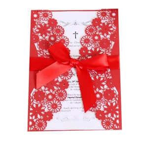 Vue macro d'invitation rouge découpée au laser avec nœud en soie et feuillet blanc