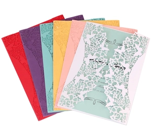 Close-up of laser-cut wedding invitations with butterfly and flower lace patterns in 7 colors