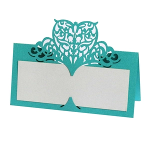 Detail of laser cut heart design on tiffany blue place cards for wedding seating