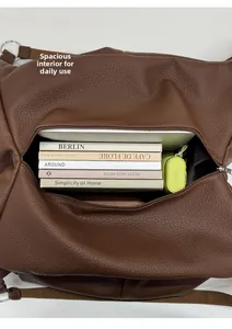 Close-up of the spacious main compartment showing books and an umbrella inside