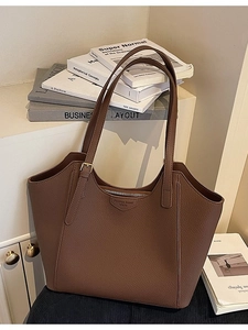 Brown lychee leather tote bag with adjustable straps and front metal buckle detail