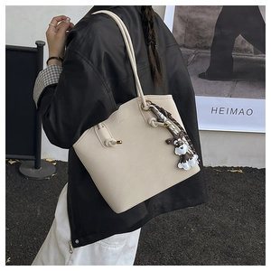Detail of off-white lychee leather tote bag with schnauzer charm and checkered silk scarf