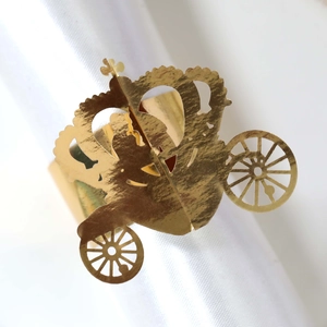 Detail of golden pumpkin carriage napkin ring with crown on white satin fabric