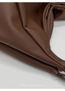 Close-up of premium brown lychee grain leather texture on retro style tote bag