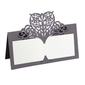 Detailed laser-cut heart pattern on purple wedding place cards with blank white name space