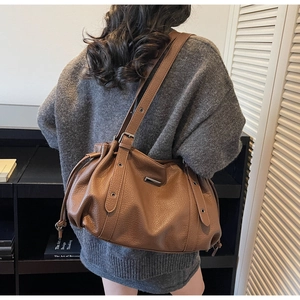 Détail du sac cabas marron texture lychee avec cordon de serrage et finitions métalliques