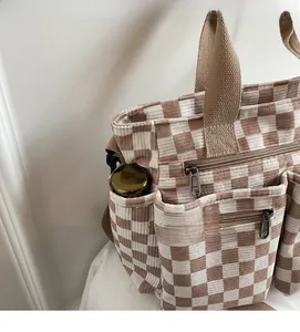Detail view of corduroy tote bag showing side pocket with thermos and YKK zipper