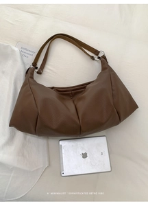 Detail of coffee brown pleated tote bag with lychee texture and wide shoulder strap