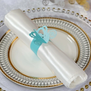 Detail of light blue laser-cut carriage napkin ring on an elegant dinner plate