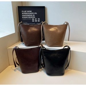 Detailed matrix view of four vintage leather bucket bags in brown, tan, maroon, and black
