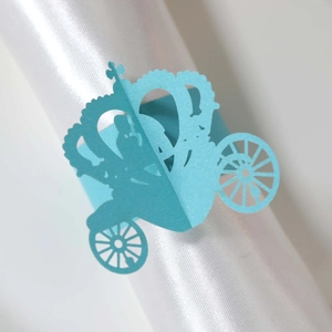 Detail view of light blue laser-cut paper napkin ring featuring a royal pumpkin carriage design