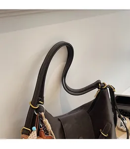 Detail of vintage dark brown tote bag showing smooth faux leather and gold hardware