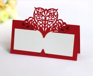 Close-up of red laser-cut heart seat cards with white inserts for wedding table setting