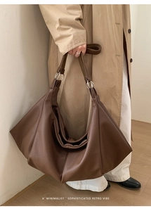 Close-up of brown litchi pattern faux leather tote bag with silver ring hardware detail