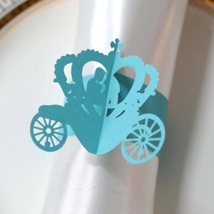 Macro detail of sky blue laser-cut paper napkin ring with pumpkin carriage and crown design