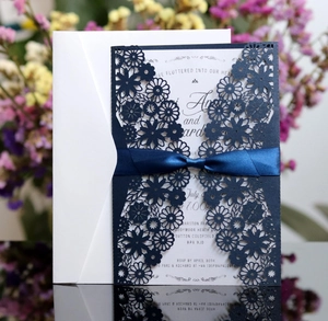 Détail de l'invitation de mariage bleue découpée au laser avec insert blanc et ruban