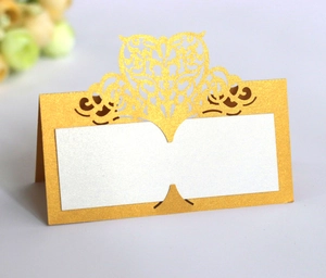 Detailed side view of laser-cut gold wedding place card with elegant scroll patterns