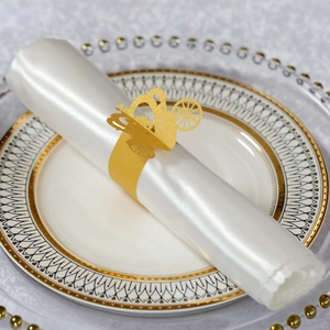 Macro view of golden laser-cut paper napkin ring in elegant carriage design for wedding